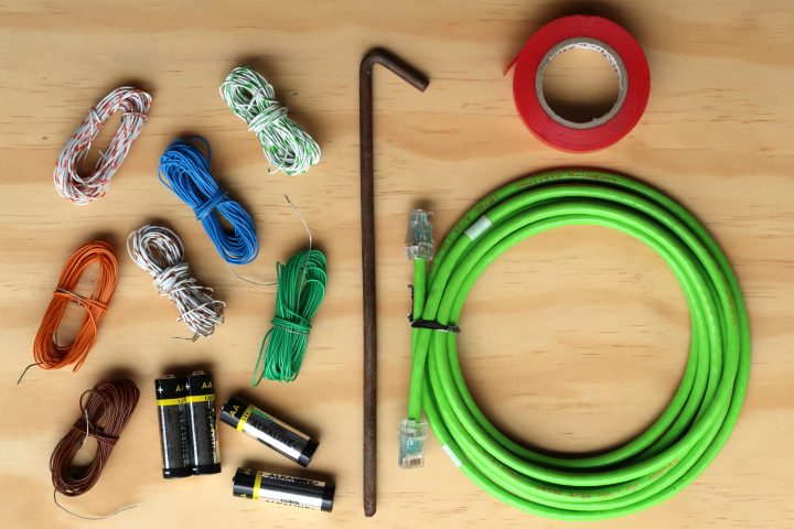 Steel tent peg, AA batteries, insulation tape, network cable and bundles of thin insulated wire