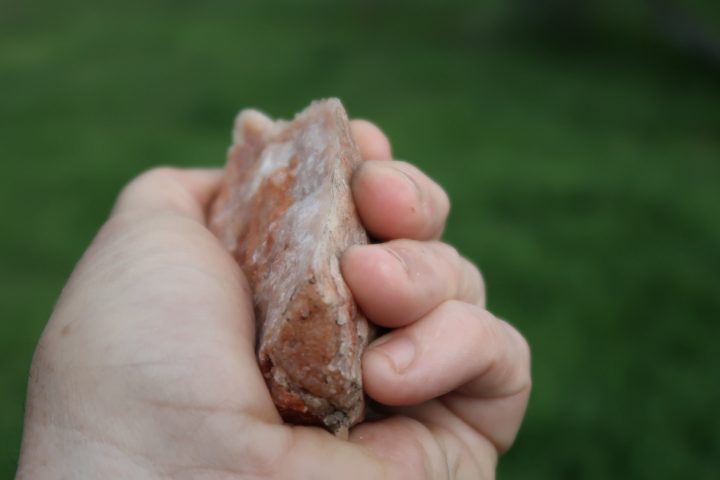 a fist sized piece of quartz held in the hand